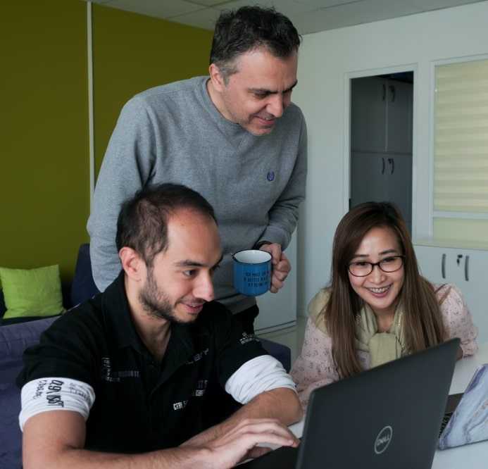 Group of people smiling while seeing on the laptop screen