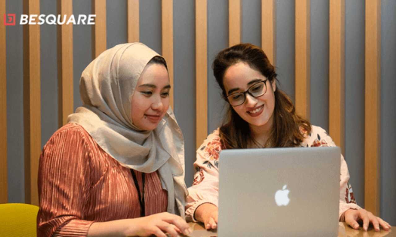 Two women looking at a laptop researching graduate programmes in Malaysia and BeSquare